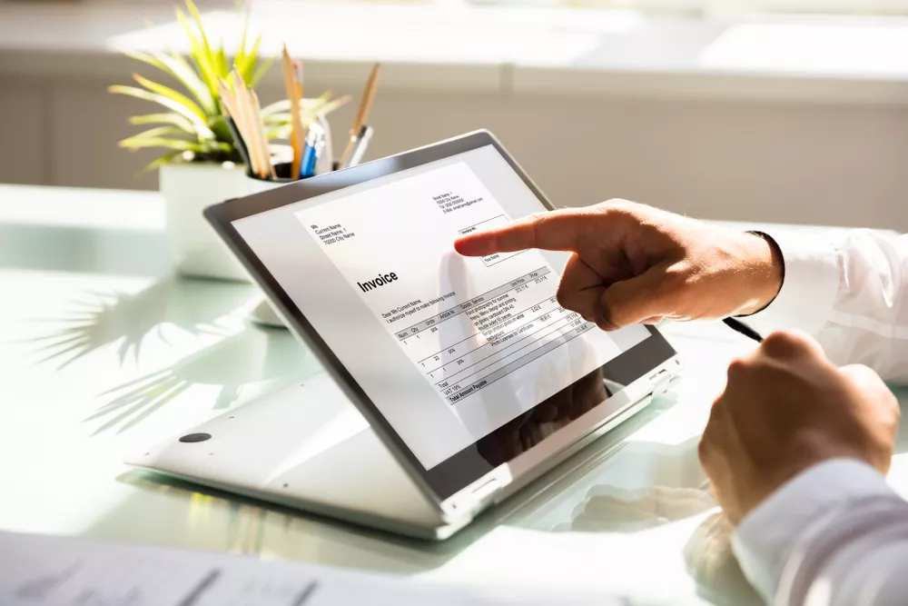 homem analisando documento no computador