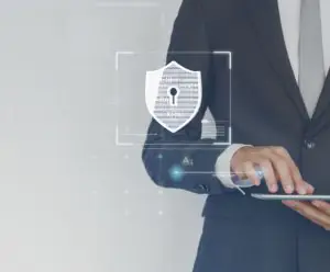 Homem de terno utiliza seu tablet. No centro da imagem, projeção virtual de um ícone de cadeado, simbolizando segurança da informação