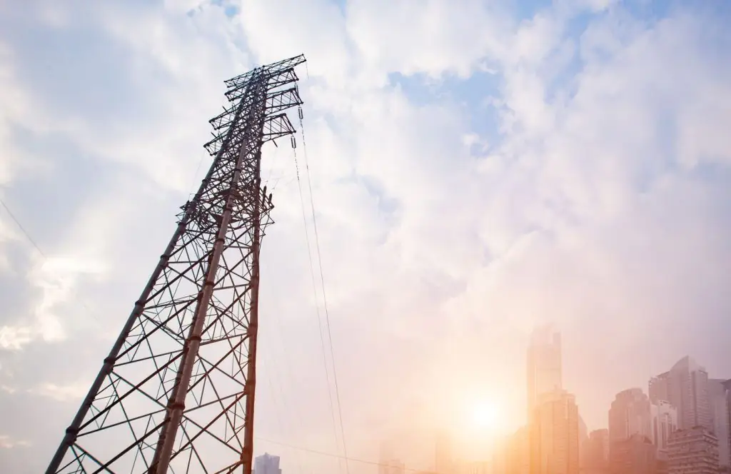 Vista de uma torre de internet durante o pôr do sol em um céu com nuvens
